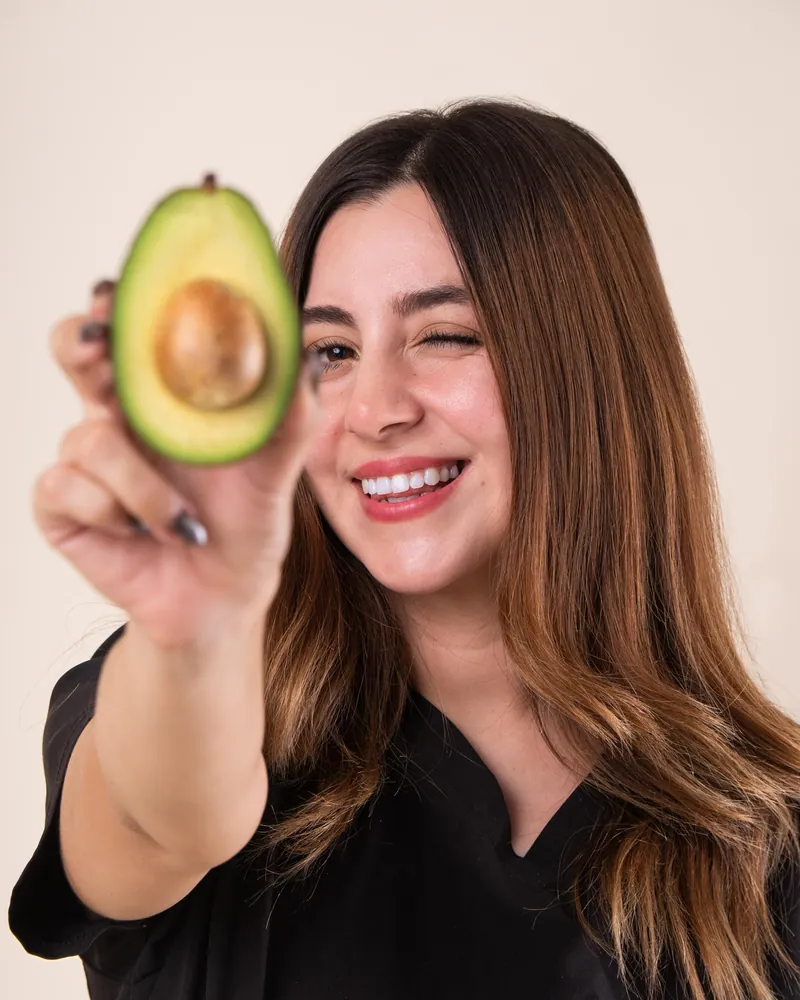 Nutrióloga Brenda Castro con un aguacate, acompañamiento nutricional en Tijuana