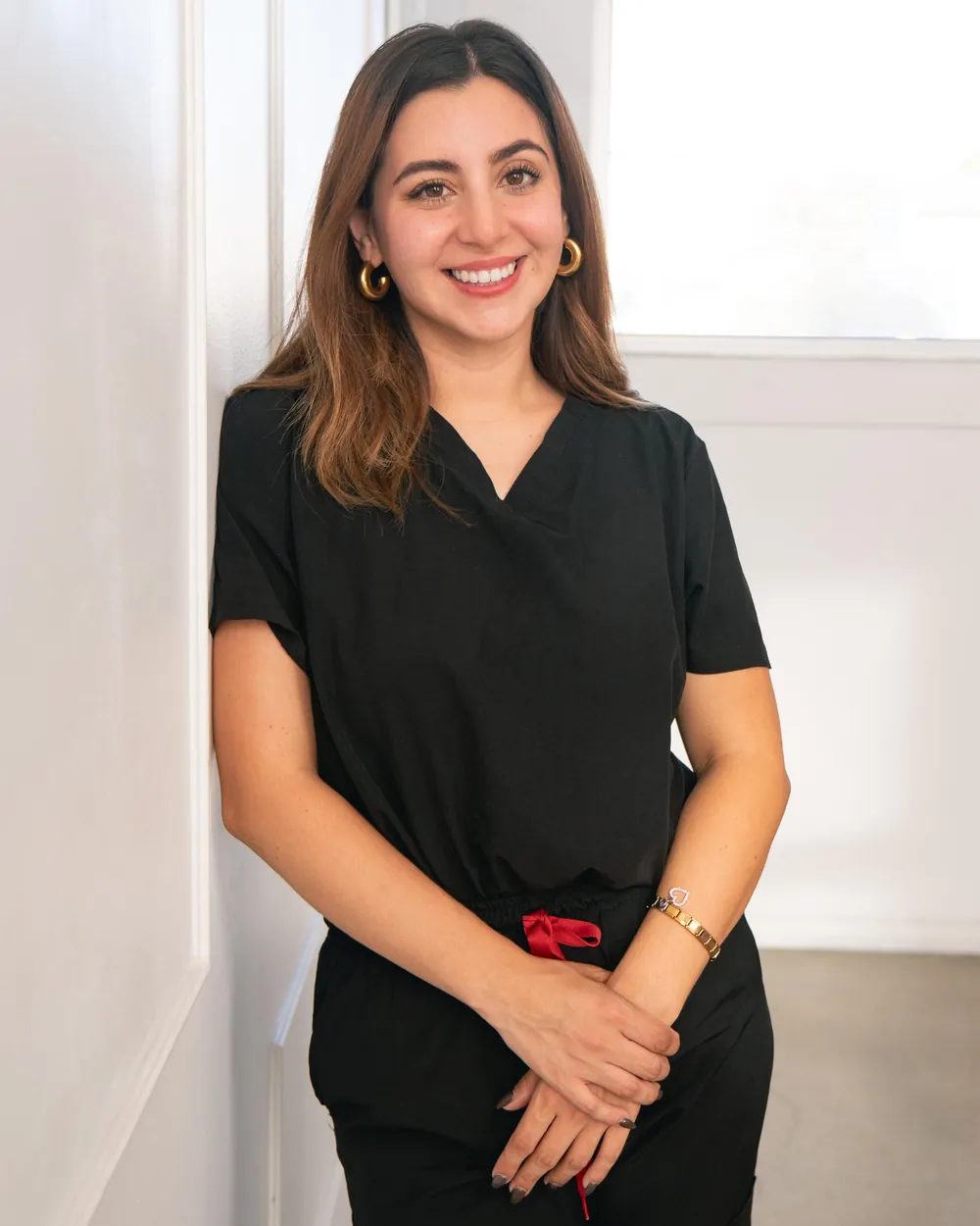 Brenda Castro, nutrióloga en Tijuana, sonriendo con uniforme clínico en el consultorio de Nutri Tijuana